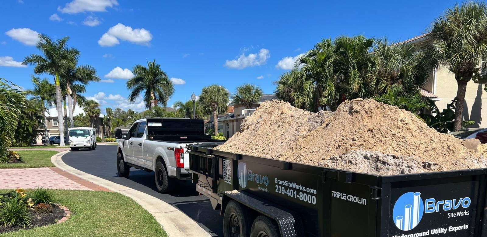 Loaded Bravo Site Works dump trailer supporting material movement in Southwest Florida