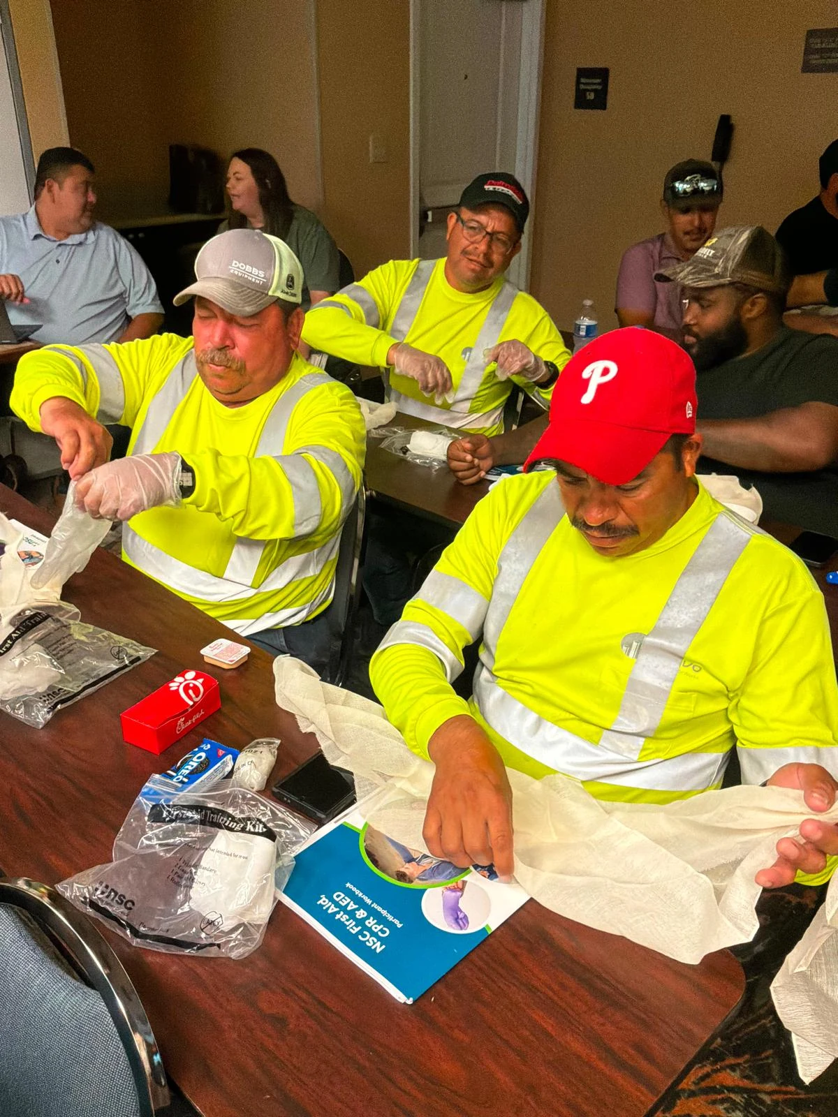 Classroom safety-training participants working with protective materials at tables