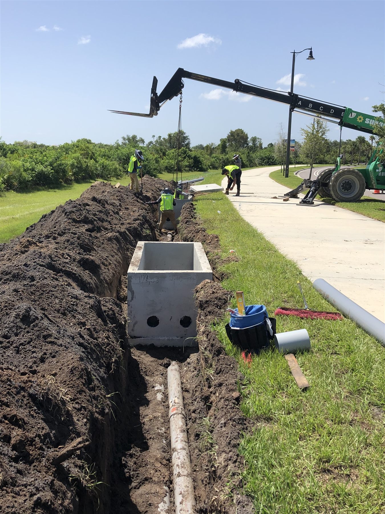 Underground utility structure installation beside a Lee County roadway